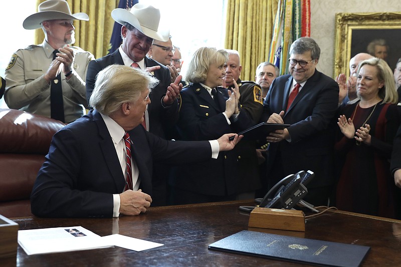President Donald Trump interacts with Attorney General William Barr in the Oval Office in mid-March. (AP Photo/Evan Vucci)