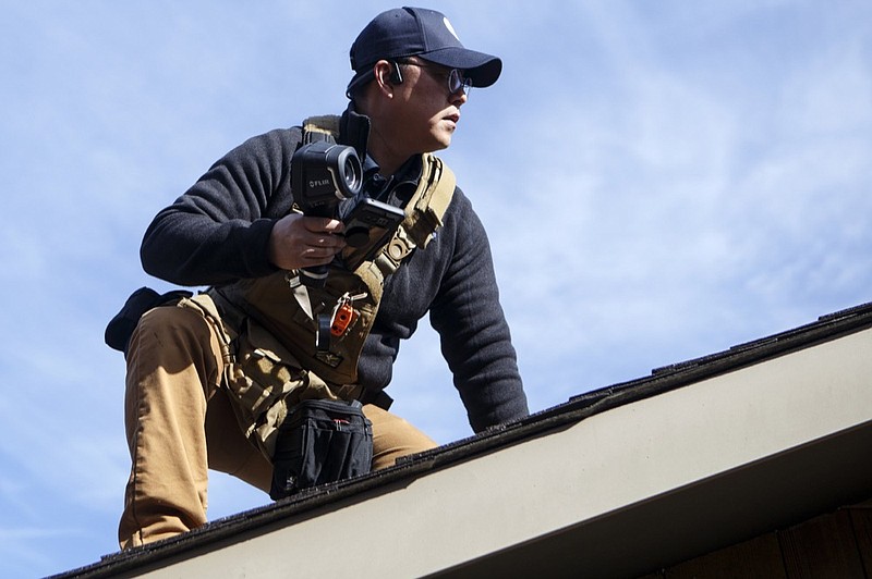 Jae Yu inspects the roof of a home on Tuesday, March 19, 2019 in Chattanooga, Tenn. BuiltWell charges customers $49 a month for routine maintenance and home inspections.