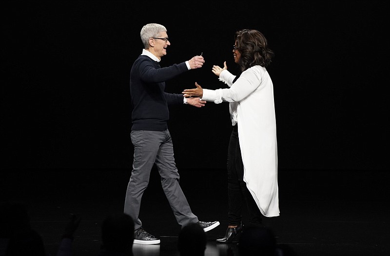 Apple CEO Tim Cook and Oprah Winfrey prepare to embrace at the Steve Jobs Theater during an event to announce new products Monday, March 25, 2019, in Cupertino, Calif. (AP Photo/Tony Avelar)