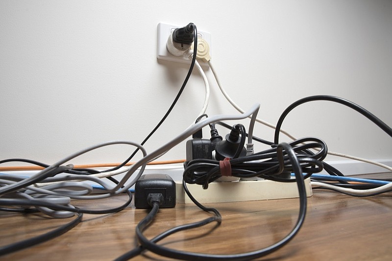 Overloaded power board in home office power outlet tile electric electricity / Getty Images