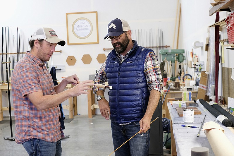 In this Sept. 15, 2017, photo co-owners of fishing rod manufacturer Tom Morgan Rodsmiths, Matt Barber, left, and Joel Doub inspect a rod during the build process at the company in Bozeman, Mont. When Barber and Doub bought the company two years ago, the plan was for previous owner Tom Morgan to stay with the business for five years to mentor them. But six months after the deal closed, Morgan died unexpectedly. (Paige McAfee/Tom Morgan Rodsmiths via AP)