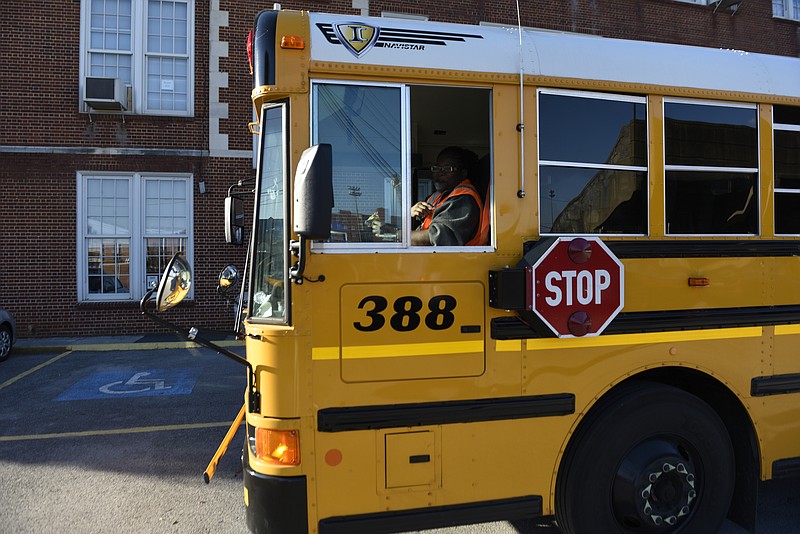 Latricia Lloyd, a driver for Durham, waits in bus number 388 to pick up students at the end of the day at the Chattanooga School for the Arts and Sciences on Monday, Dec. 7, 2015, in Chattanooga, Tenn.