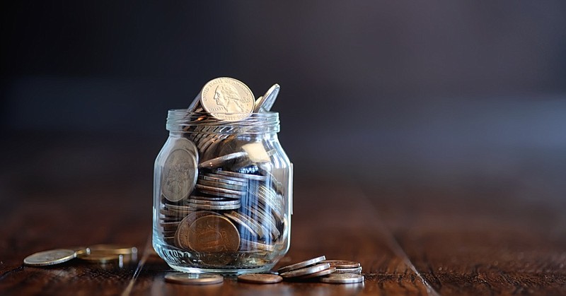 Coins in a glass jar on a wooden floor. Pocket savings from coins in the bank. Piggy bank in a glass jar with coins. money budget tile banking tile / Getty Images