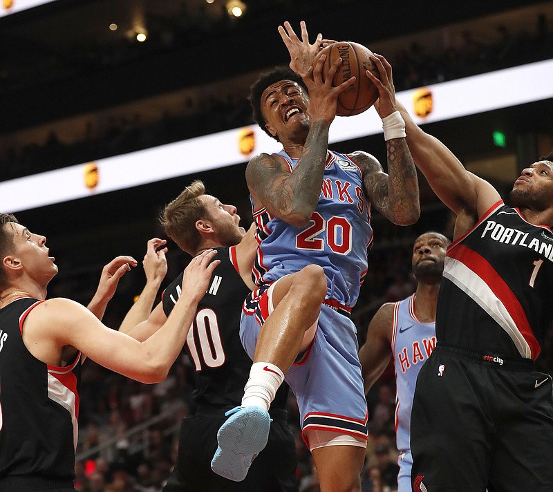 Atlanta Hawks forward John Collins (20) comes down with a rebound against Jake Layman (10), Evan Turner (1) and other Portland Trail Blazers players during Friday night's game in Atlanta.