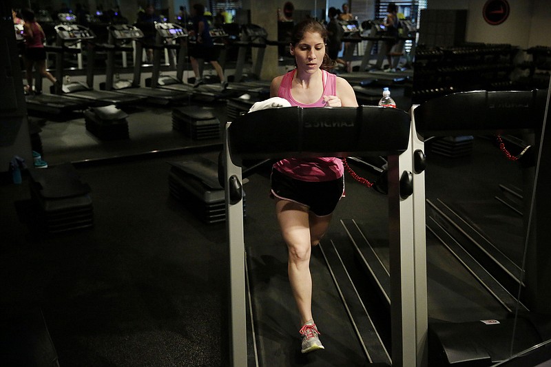 A woman runs on the treadmill during a "Cross Tread" at a fitness center.