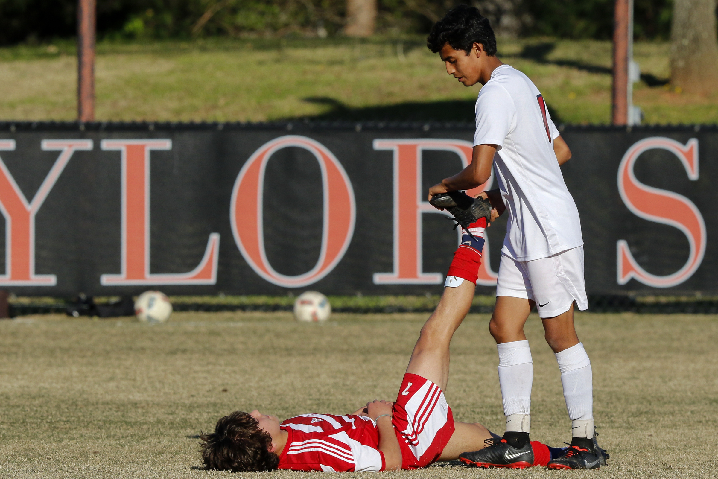 Dalton's Uriel Mendoza (4) helps stretch out Baylor's Ethan Nunes (7) at Baylor School on Tuesday, April 2, 2019 in Chattanooga, Tenn.