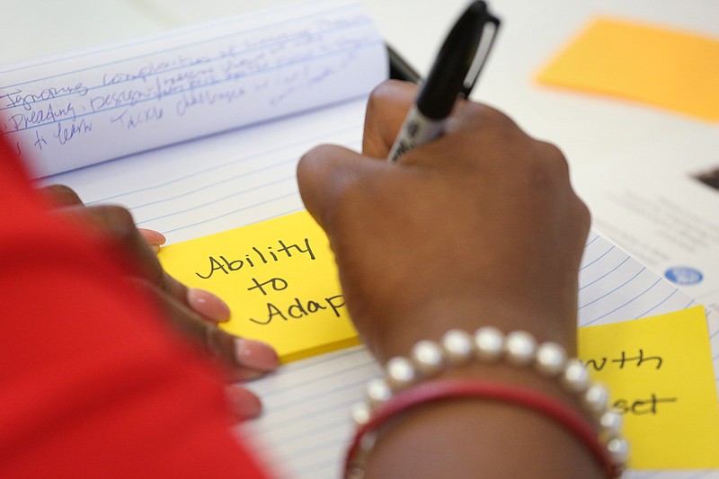 An attendee at a visioning event for Howard Middle School last August writes down ideas for what students should be able to do in the renovated facility, which is being paid for by bonds from a de facto 2017 tax increase.