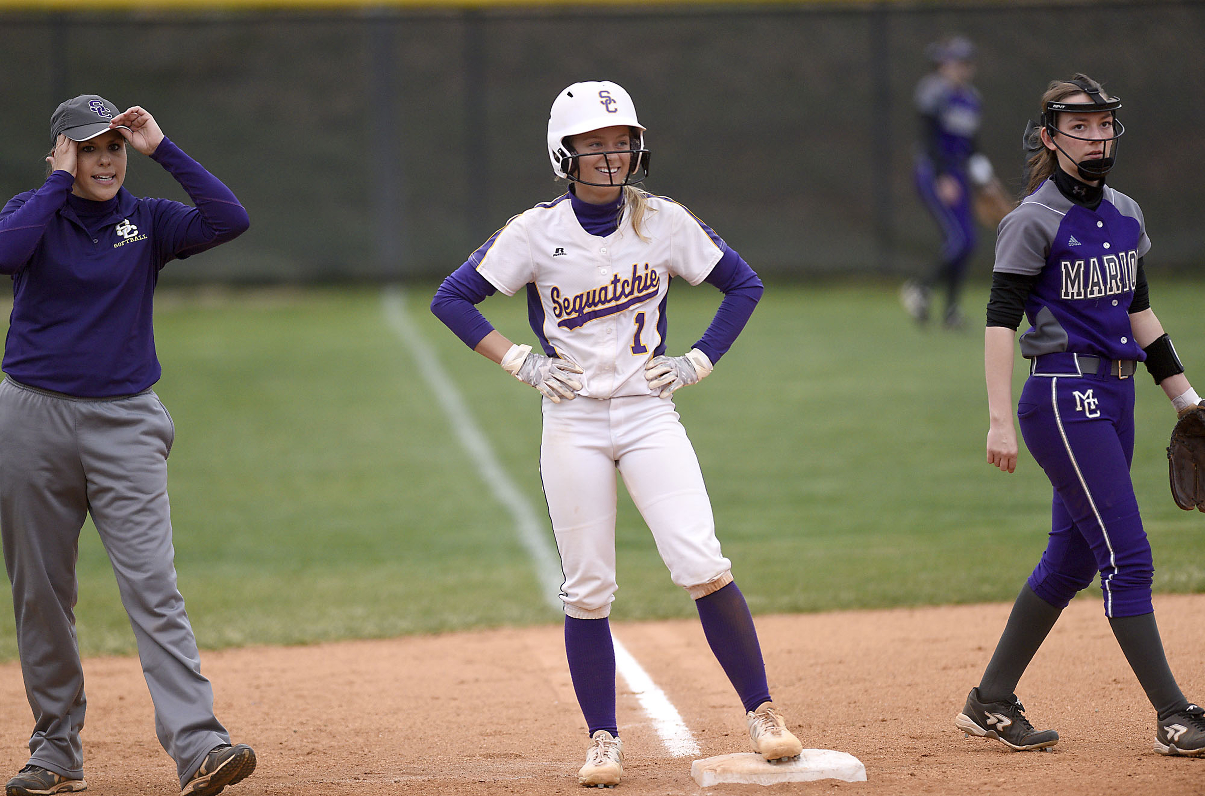 Sequatchie's Ella Edgmon (1) smiles as she stand on third after hitting a triple. At left is Indian head coach Kelly Somerville, and at right stands Marion third baseman Emmie Sneed (12). The Marion County High Lady Warriors visited the Sequatchie County Lady Indians in TSSAA softball action on April 4, 2019.