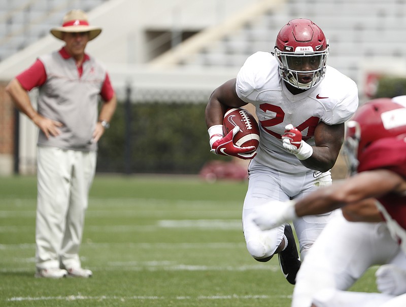 Alabama junior running back Brian Robinson looks for running room as coach Nick Saban looks on during Saturday's scrimmage in Tuscaloosa.