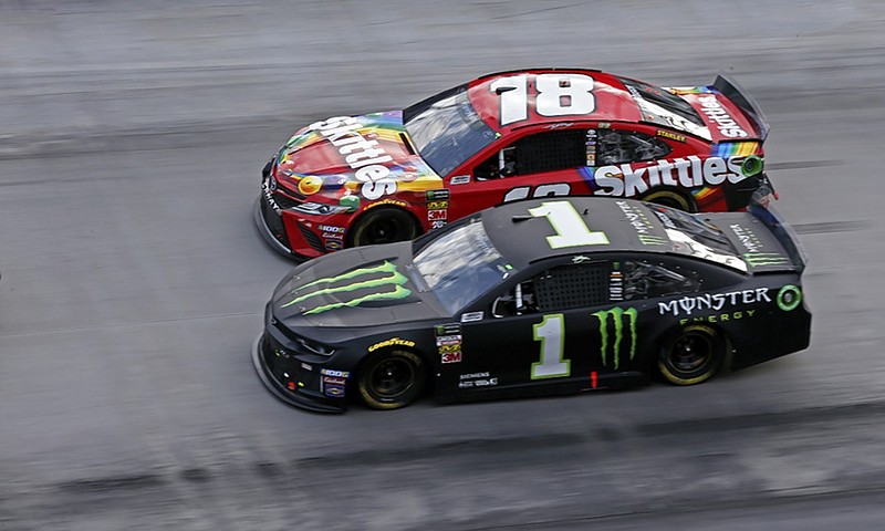 Kyle Busch (18) and his older brother Kurt Busch (1) compete for position after a restart during Sunday's NASCAR Cup Series race at Bristol Motor Speedway.