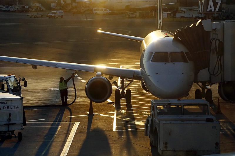 FILE - In this Dec. 8, 2018, file photo, a worker fuels a Delta Connection regional airlines passenger jet at Logan International Airport in Boston. Delta Air Lines Inc. reports financial results Wednesday, April 10, 2019.(AP Photo/Bill Sikes, File)