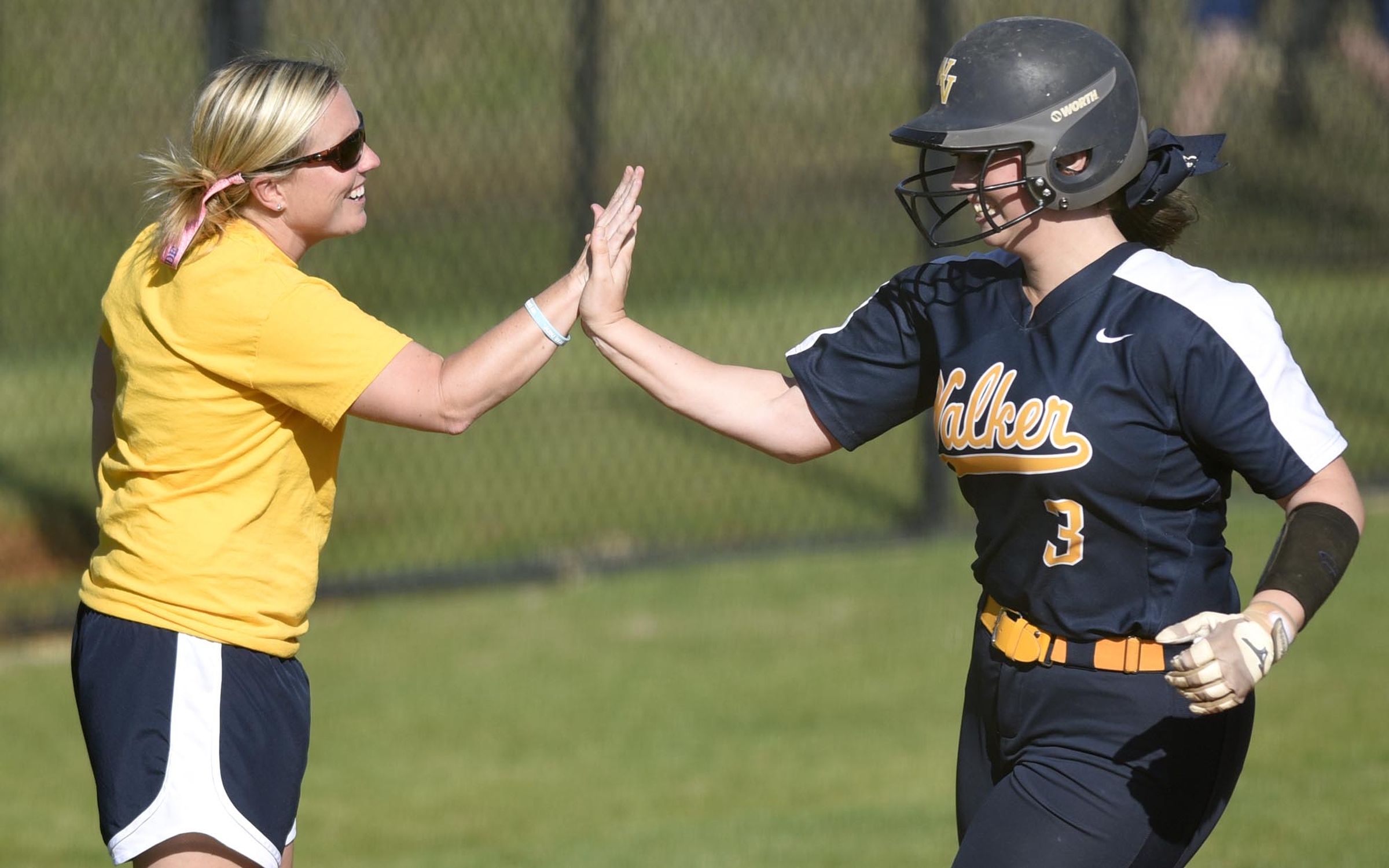 Walker Valley softball coach Lauren Limburg high-fives Hannah Kate Singleton as she rounds third base after hitting a home run during the Lady Mustangs' 18-0, five-inning win at East Hamilton on Wednesday.
