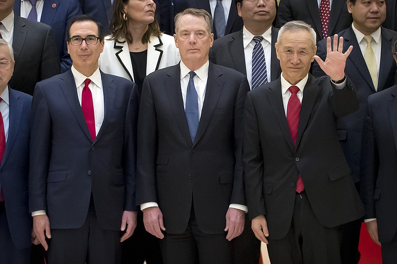 FILE - In this Feb. 15, 2019, file photo, Chinese Vice Premier Liu He, right, gestures as he and U.S. Treasury Secretary Steven Mnuchin, left, and U.S. Trade Representative Robert Lighthizer pose for a group photo at the Diaoyutai State Guesthouse in Beijing. China said Thursday, April 11, 2019, that trade talks with the U.S. are "moving forward" after nine rounds of consultations aimed at ending a standoff that has shaken the world economic outlook. (AP Photo/Mark Schiefelbein, File)
