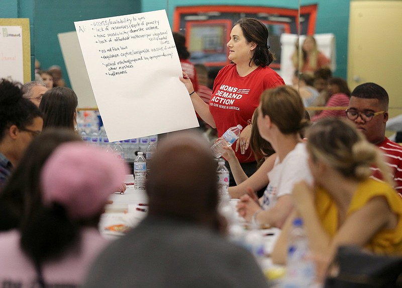 Staff photo by Erin O. Smith / Jill Weitz with Moms Demand Action reads off what she and her group came up with for what fuels gun violence during the Cost of the Crossfire forum hosted by the Chattanooga Times Free Press Wednesday, April 10, 2019 at the Carver Youth and Family Development Center in Chattanooga, Tennessee. Some of their ideas included access to guns, toxic masculinity and hopelessness.