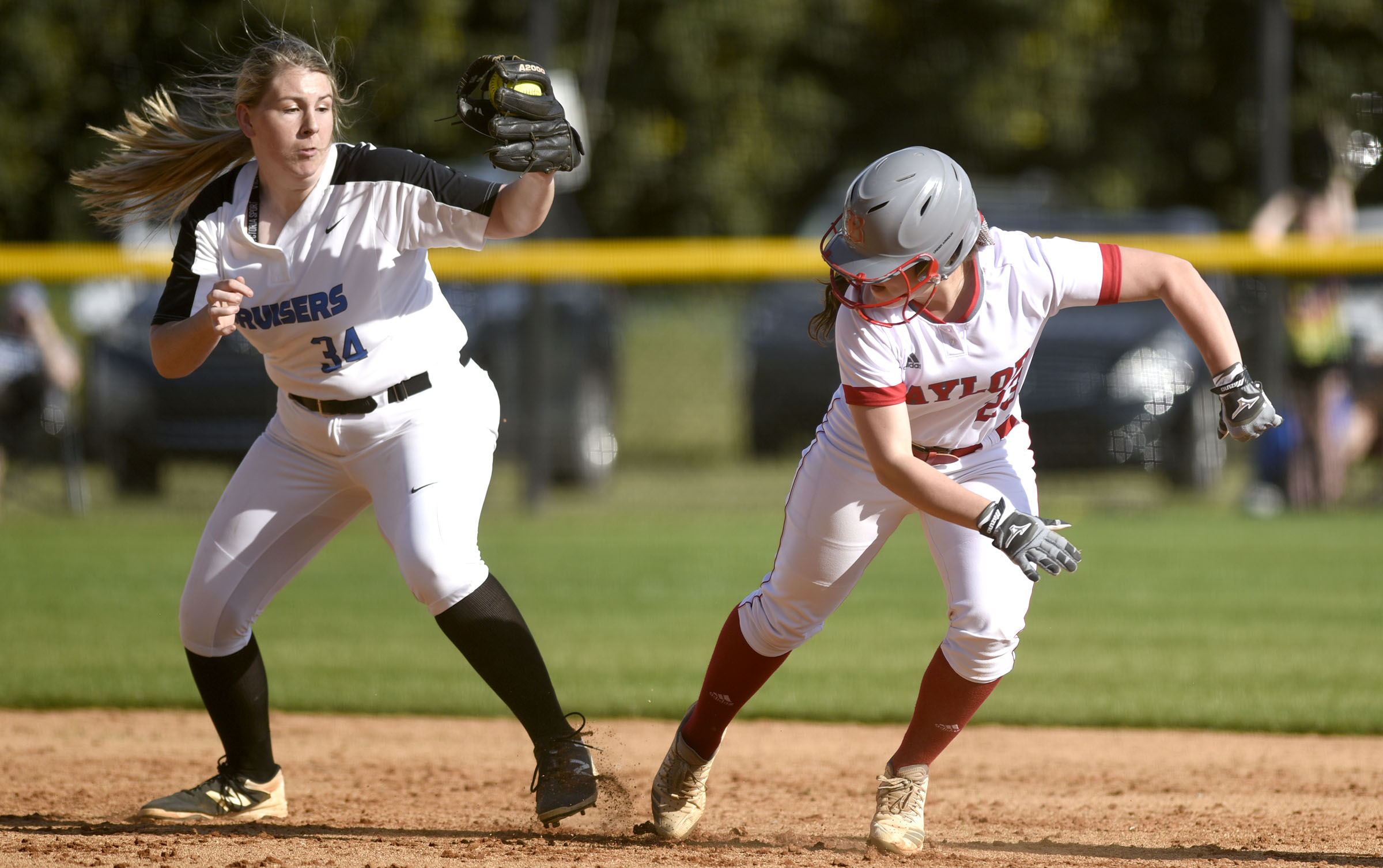 GPS pitcher Mazy Ann McKnight (34) blocks the path of Baylor's Sophie Piskos (23) turning a rundown between first and second base. Piskos was out on the play. The Baylor Lady Raiders visited the Girls Preparatory School Bruisers in TSSAA softball action. The Bruisers won 5 to 0.