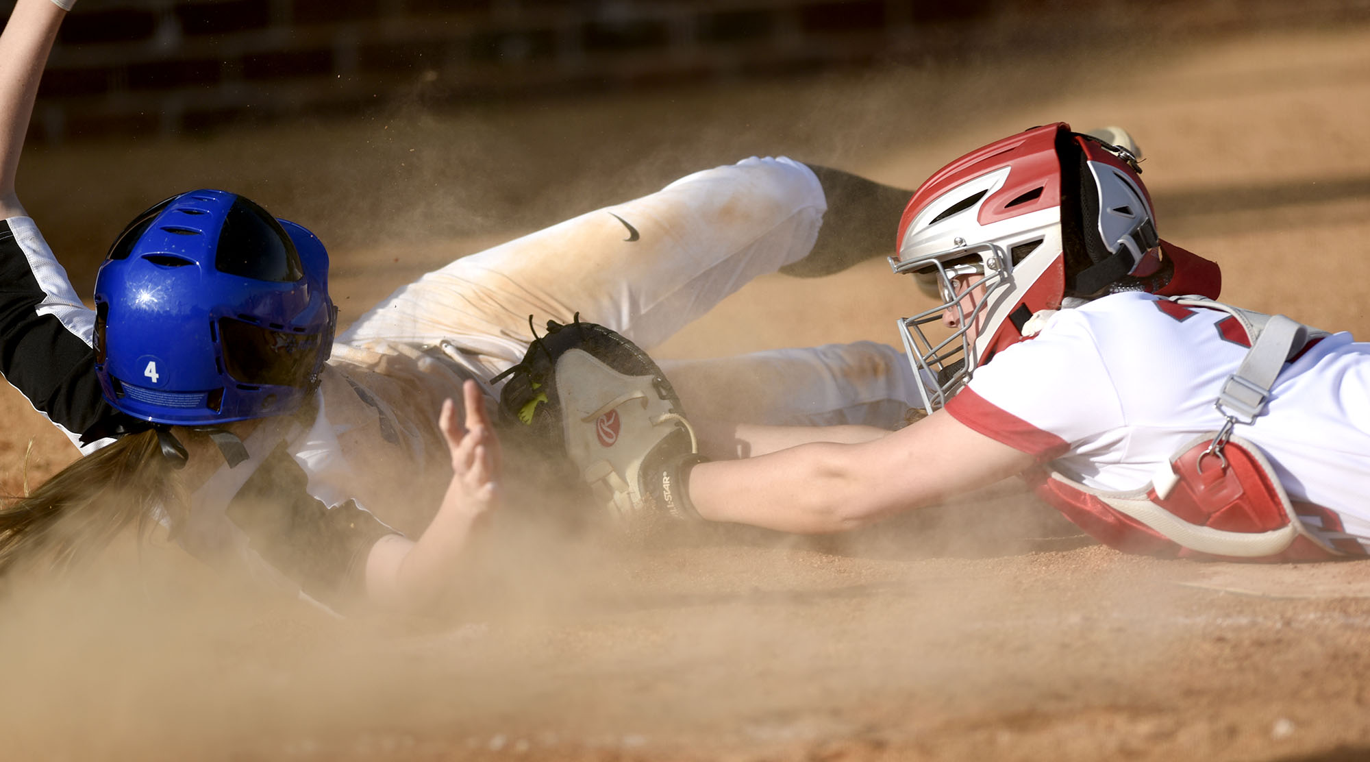 GPS's Brynley Oliver (4) sprawls after scoring at home just ahead of the tag of Baylor catcher Sophe Piskos (23). The Baylor Lady Raiders visited the Girls Preparatory School Bruisers in TSSAA softball action. The Bruisers won 5 to 0.