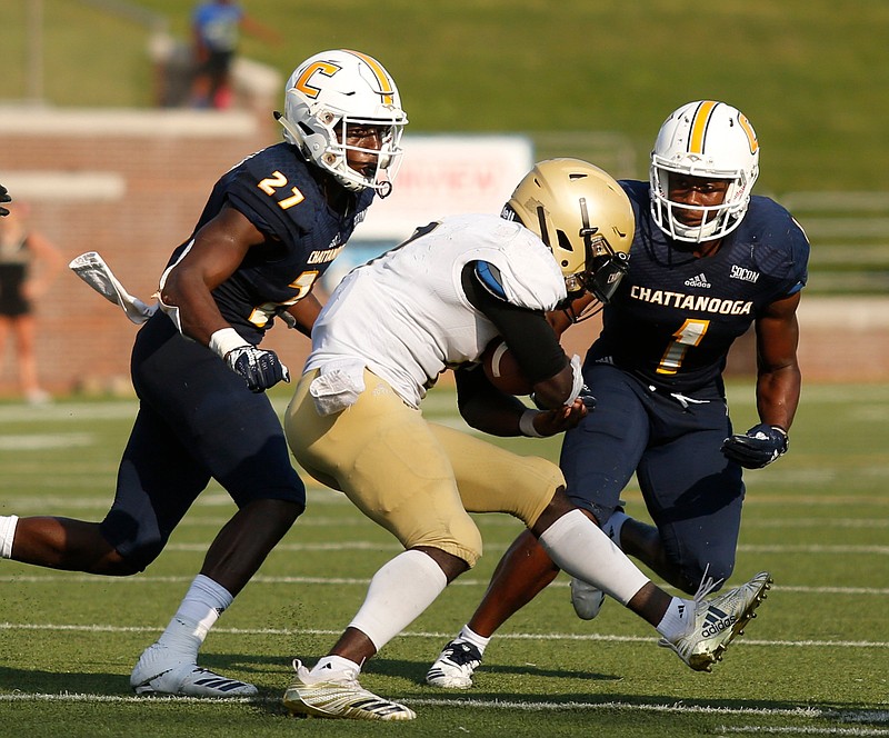 UTC defensive backs Jerrell Lawson, left, and Brandon Dowdell, right, converge on Wofford halfback Lennox McAfee during a SoCon football game at Finley Stadium in October 2018.