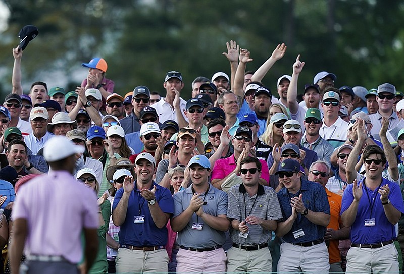 Patrons clap for Tiger Woods as he walks off the 18th green Saturday at Augusta National Golf Club after completing his third round at the Masters.