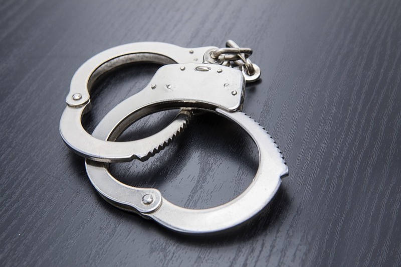 
Closeup of silver handcuffs detaining crime prisoners. Shot on the wooden table arrest tile arrests / Getty Images