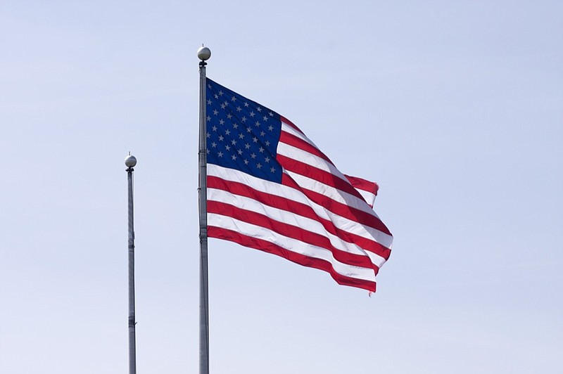 
American flag waving in clear sky american flag tile / Getty Images