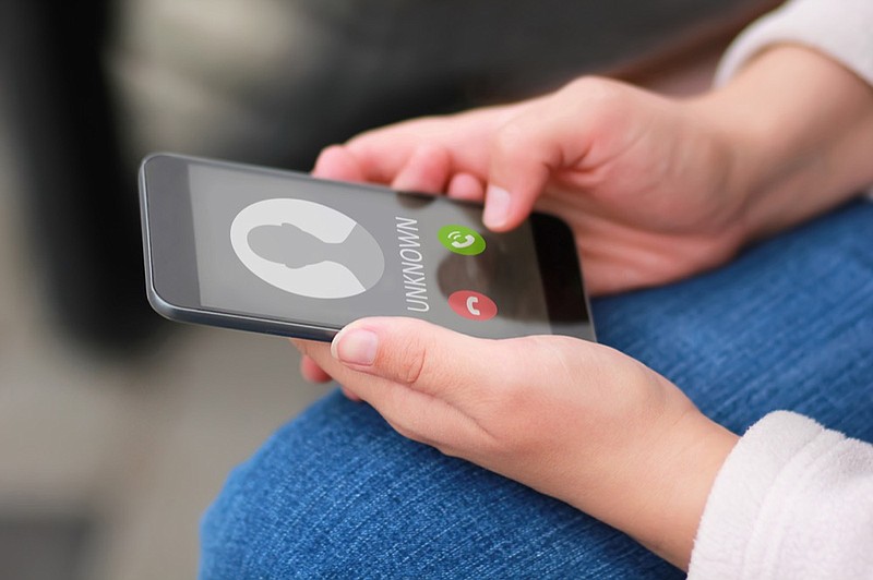 Close up of woman's hands with smartphone and unknown incoming phone call on it, fraud or scam schemes phone tile scam fraud robocall / Getty Images