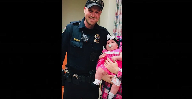 Chattanooga Police officer Joseph Coleman holds five-month-old Lakelynn Durhan. Coleman is credited with saving Lakelynn's life after administering CPR when the baby stopped breathing in February 2018. 
