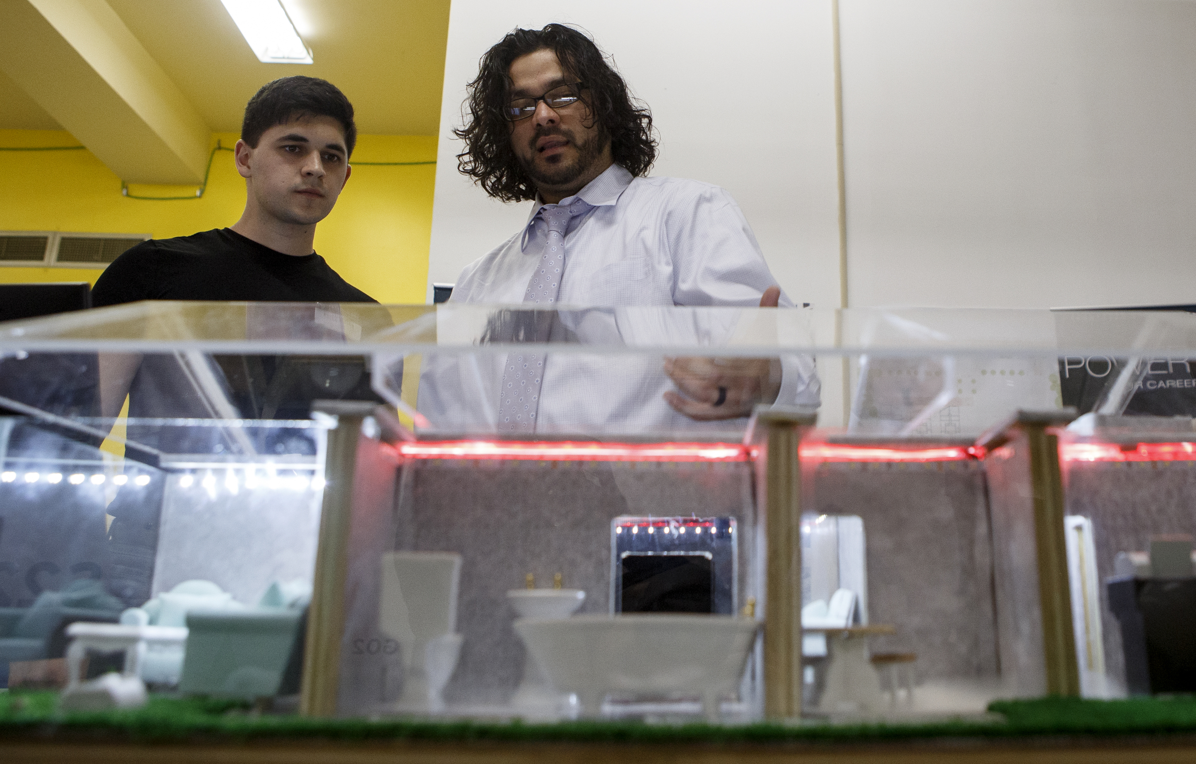 Electrical engineering student Otniel Gonzalez, right, explains the features of his team's LabVIEW smart home model to Brian Taylor, a senior mechanical engineering student, during the University of Tennessee at Chattanooga College of Engineering and Computer Science's Technology Symposium at the downtown Public Library on Thursday, April 18, 2019 in Chattanooga, Tenn. Gonzalez is also a senior. The model demonstrated the features of the LabVIEW program which helps to create a more cost-effective smart home, including security features and electrical efficiency controls.
