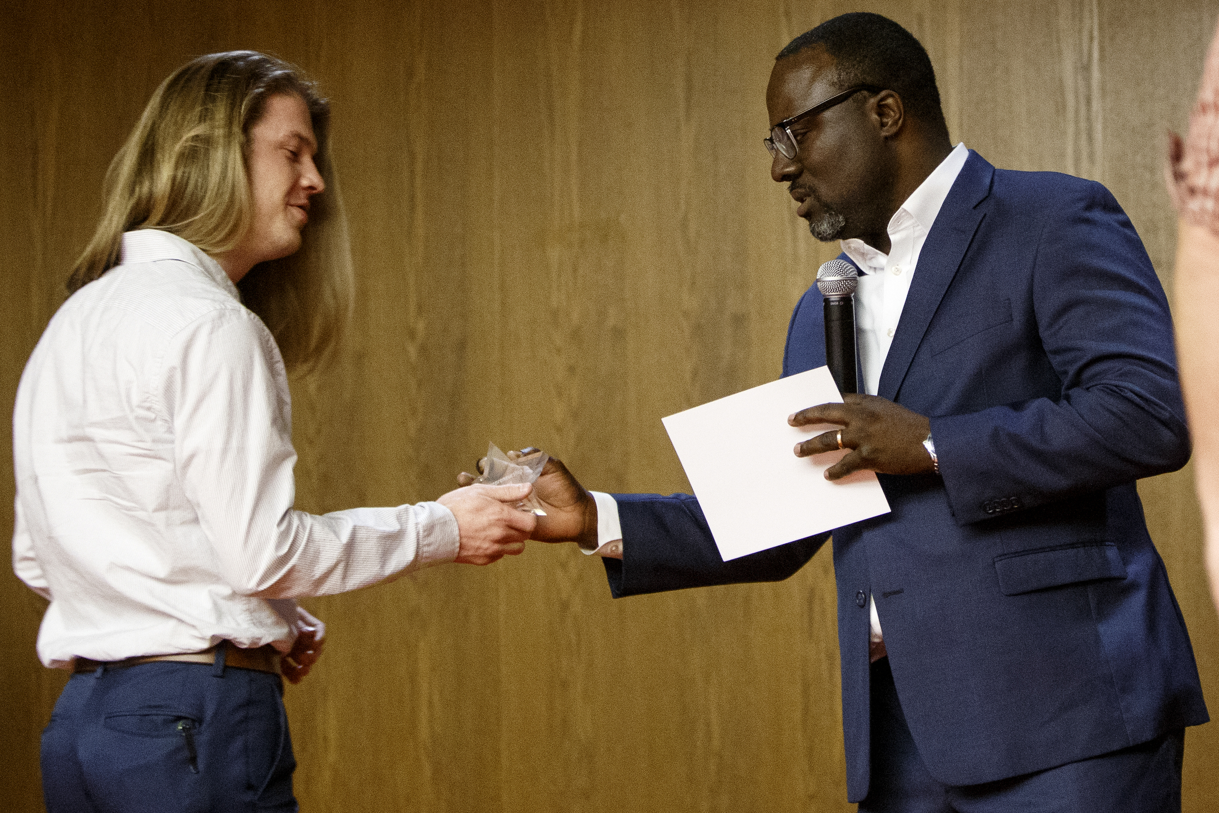 CO.LAB CEO Marcus Shaw, right, presents an award to Evan Lane, a senior electrical engineering student, during the awards ceremony for the University of Tennessee at Chattanooga College of Engineering and Computer Science's Technology Symposium at the downtown Public Library on Thursday, April 18, 2019 in Chattanooga, Tenn. Lane was a part of the four-person team that developed the Open Spots app that helps people find open parking spaces in a parking lot on UTC's campus. By winning the CO.LAB award, the Open Spots team now has a chance to participate CO.LAB's CO.STARTERS entrepreneurial summer program.