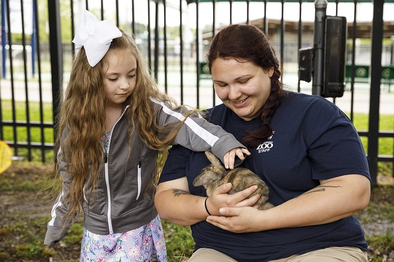 Lilyanna Stone pets a bunny held by Angelica Hodge at the annual Hug-a-Bunny event at the Chattanooga Zoo on Friday, April 19, 2019, in Chattanooga, Tenn. The event which also includes inflatables and games for children continues Saturday from 9 a.m. to 5 p.m.