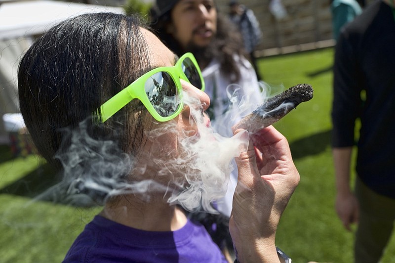 FILE - In this Friday, March 22, 2019 file photo, a participant takes a very smoky puff from a marijuana cigarette during at meet and greet at "Tommy Chong's Live, Love, and Smoke Tour hosted by GreenTours in the Woodland Hills section of Los Angeles. U.S. retail sales of cannabis products jumped to $10.5 billion last year, a threefold increase from 2017, according to data from Arcview Group, a cannabis investment and market research firm. The figures do not include retail sales of hemp-derived CBD products. (AP Photo/Richard Vogel, File)

