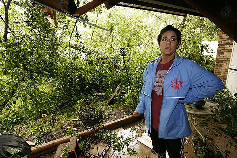 Sonya Banes reacts to a large oak tree that crashed through the patio of her mother's house in Learned, Miss., Thursday, April 18, 2019. Several homes were damaged by fallen trees in the community. Strong storms again roared across the South on Thursday, topping trees and leaving more than 100,000 people without power across Mississippi, Louisiana and Texas. (AP Photo/Rogelio V. Solis)

