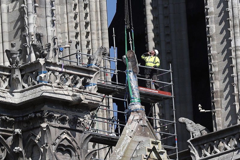 A worker prepares to remove a statue from the damaged Notre Dame cathedral, in Paris, Friday, April 19, 2019. Rebuilding Notre Dame, the 800-year-old Paris cathedral devastated by fire this week, will cost billions of dollars as architects, historians and artisans work to preserve the medieval landmark. (AP Photo/Thibault Camus)


