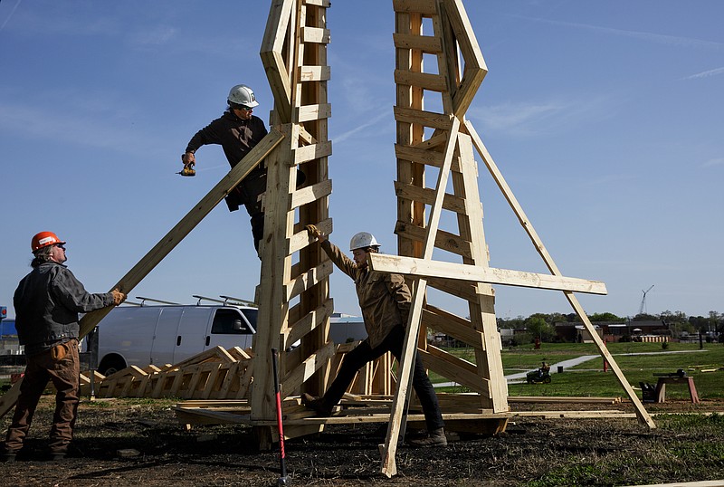 Dan Rather, left, artist Andrew Nigh, center, and Henry Wolf construct a 30-foot sculpture titled "Aster Origamus" that was the featured 2018 sculpture burn.