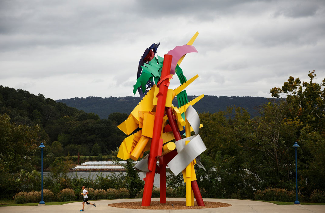 A jogger passes a sculpture by artist Albert Paley at the Blue Goose Hollow trailhead of the Tennessee Riverpark.