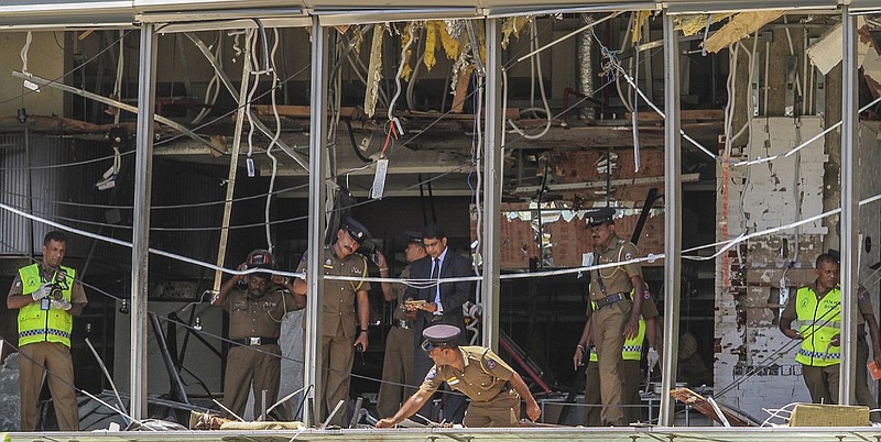 In this Sunday April 21, 2019, photo, a Sri Lankan Police officer inspects a blast spot at the Shangri-la hotel in Colombo, Sri Lanka. Sri Lankan authorities blame seven suicide bombers of a domestic militant group for coordinated Easter bombings that ripped through Sri Lankan churches and luxury hotels which killed and injured hundreds of people. It was Sri Lanka's deadliest violence since a devastating civil war in the South Asian island nation ended a decade ago. (AP Photo/Chamila Karunarathne, file)