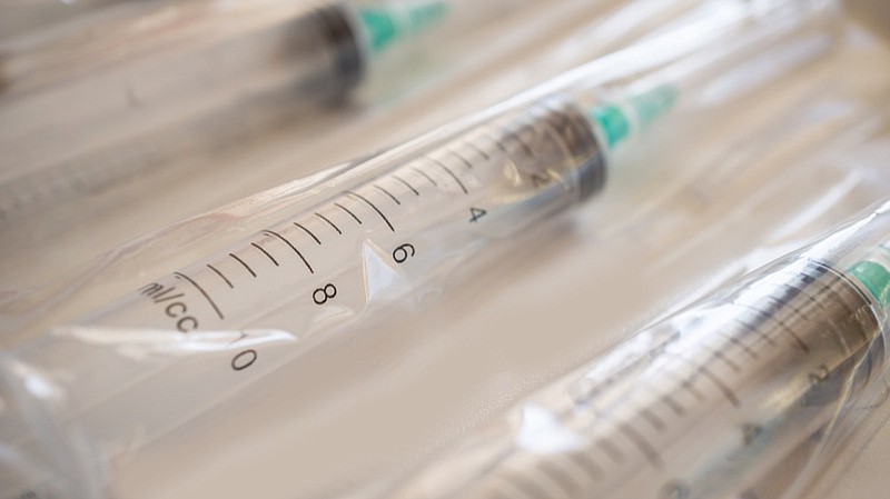 disposable plastic syringes with needles in the package. Macro shot. syringe bag / Getty Images