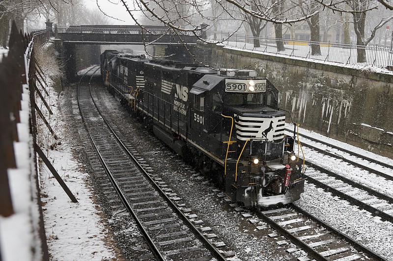 FILE- In this March 3, 2019, file photo a Norfolk Southern freight train passes through the Northside of Pittsburgh. The Norfolk Southern Railway reports earnings Wednesday, April 24. (AP Photo/Gene J. Puskar, File)