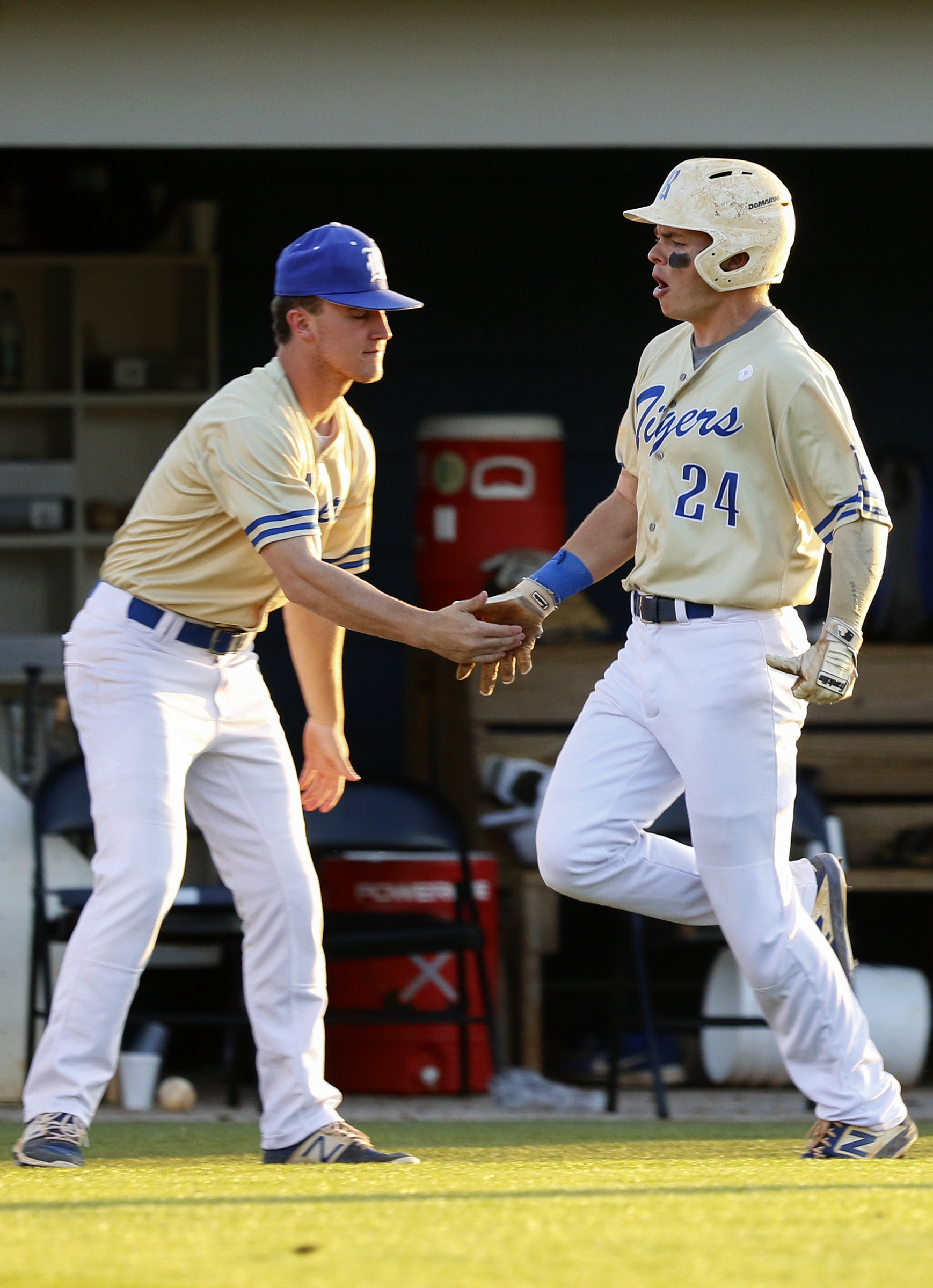 Ringgold's Holden Tucker (24) slaps hands with teammate Dylan Wright as he makes his way to the plate after hitting a solo home run during the second game of a doubleheader against Cherokee Bluff on Wednesday at Bill Womack Field. The teams split the first two games of their GHSA Class AAA first-round series and will play a deciding third game today.