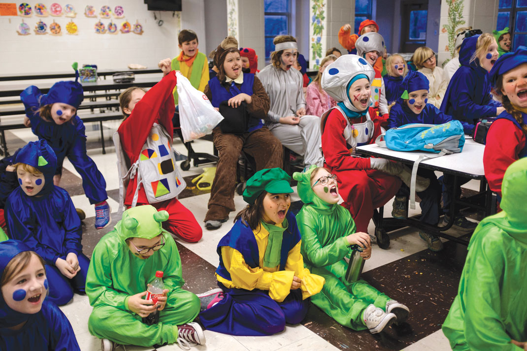 Children cheer in the cafeteria before performing in a production of 