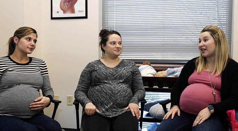 In this Jan. 29, 2019, photo provided by Mountain Area Health Education Center, from left, Hayley Heninger, Morgan Shirley and Kailee Morel Alvarez share their pregnancy experiences during a two-hour group prenatal session at Mountain Area Health Education Center in Asheville, N.C. Patients do their own blood pressure and weight checks and get a support group-style experience at the monthly sessions. Some studies have found fewer preterm births and more breastfeeding among women who participate compared with conventional individual visits. (Brenda Benik via AP)

