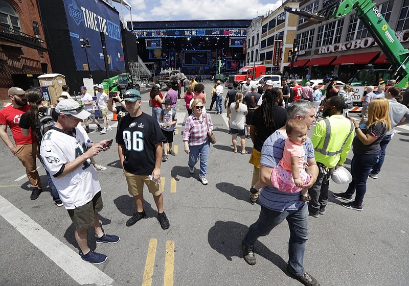 Onlookers watch the progress of the stage being built Wednesday in downtown Nashville ahead of the first round of the NFL draft. The draft starts Thursday evening and continues through Saturday.

