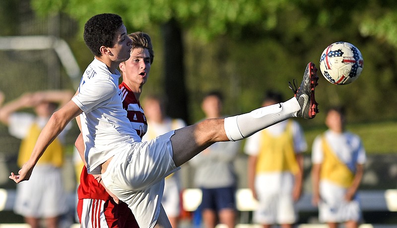 McCallie's Gui Vivaldini kicks the ball downfield ahead of Baylor's Malcolm Jett during Friday night's rivalry match at Baylor, which the visitors won 3-0.