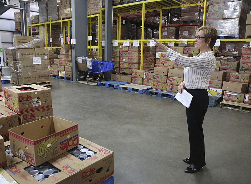 Gina Crumbliss, president and CEO of the Chattanooga Area Food Bank, points out where different stations are located in the warehouse during the launch of Hunger Action Month at the Chattanooga Area Food Bank Tuesday, Aug. 29, 2017, in Chattanooga, Tenn. 