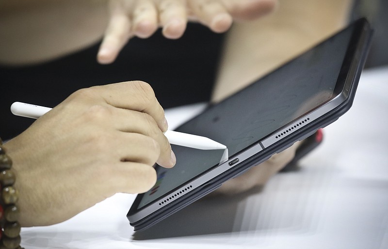 FILE - In this Oct. 30, 2018, file photo the new iPad Pro with its accessory keyboard and pencil is tested during a pre-release showcase after an event announcing new products in the Brooklyn borough of New York. Apple Inc. reports financial results Tuesday, April 30, 2019. (AP Photo/Bebeto Matthews, File)