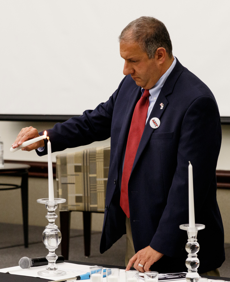 Michael Dzik lights a candle for Holocaust survivor Henry Green, who was unable to attend a Yom HaShoah ceremony at the Jewish Cultural Center due to illness, on Wednesday, May 1, 2019, in Chattanooga, Tenn. The tradition is held to honor the memories of the six million Jews killed during the Holocaust between 1941 and 1945.