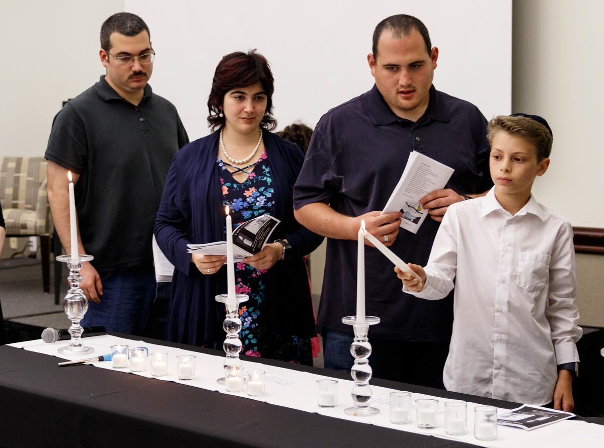 Judah Balazs, right, lights a candle with other grandchildren and great grandchildren of Holocaust survivors during a Yom HaShoah ceremony at the Jewish Cultural Center on Wednesday, May 1, 2019, in Chattanooga, Tenn. The tradition is held to honor the memories of the six million Jews killed during the Holocaust between 1941 and 1945.