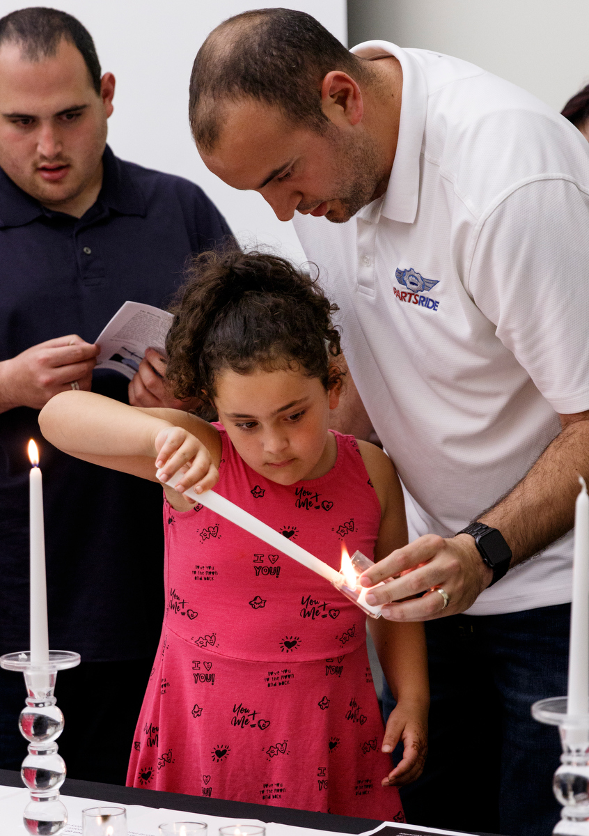 Tal Cohen helps his daughter Daniella light a candle during a Yom HaShoah ceremony at the Jewish Cultural Center on Wednesday, May 1, 2019, in Chattanooga, Tenn. The tradition is held to honor the memories of the six million Jews killed during the Holocaust between 1941 and 1945.