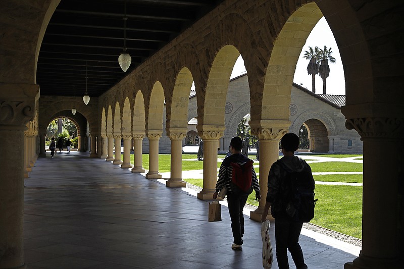 FILE - In this March 14, 2019, file photo, people walk on the Stanford University campus in Santa Clara, Calif. Financial aid award letters are known to be tricky to understand due to jargon and a lack of clarity about how much you have to pay out of pocket. If you can’t interpret your financial aid award, you won’t be able to compare letters from different schools. (AP Photo/Ben Margot, File)