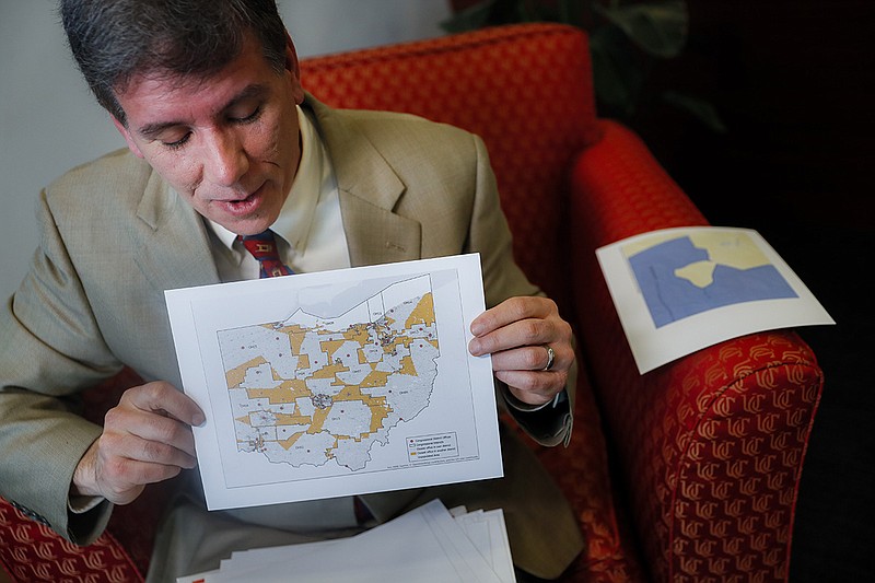 David Niven, a professor of political science at the University of Cincinnati holds a map displaying the wide disparity of Ohio congressional district office locations, with orange locations representing areas whose office are found outside it's own district's bounds, Thursday, April 11, 2019, in Cincinnati. Congressional Democrats nationwide had a good year in 2018, gaining 40 seats. But Republicans held fast with 75% of Ohio s House seats, despite winning only 52% of Ohio s congressional vote total. Not a single seat has changed hands, said Niven, who testified for those challenging Ohio s map. Not a single seat. The point of this map was to build a seawall against the storm, and it has held. (AP Photo/John Minchillo)