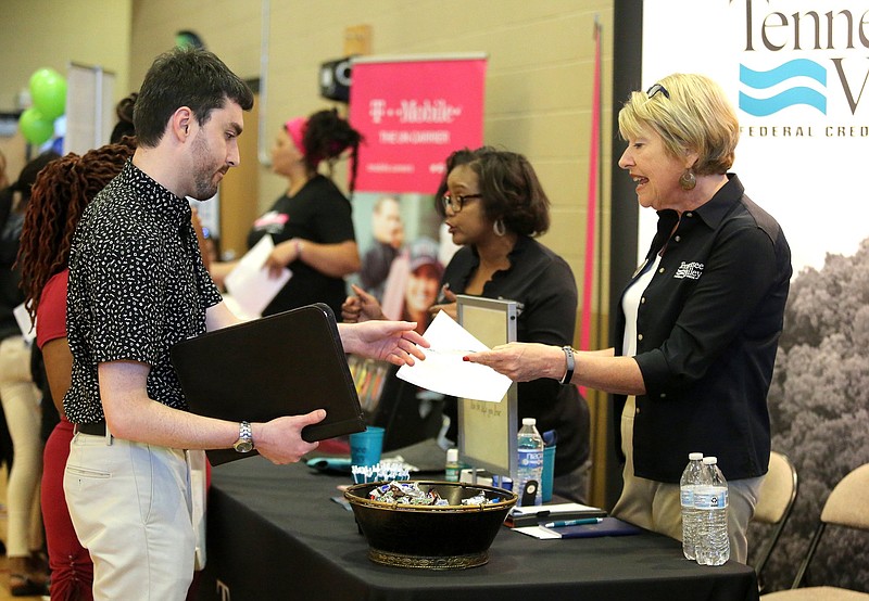 Sean Booth, a job seeker, hands his resume to Susan Dietz, a recruiting training manager with Tennessee Valley Federal Credit Union, during the Chattanooga Chamber Spring Job Fair held at Brainerd Crossroads Thursday, May 2, 2019 in Chattanooga, Tennessee. 